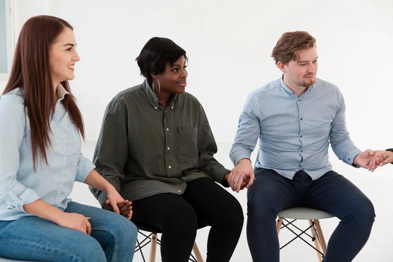 Радостные пациенты на реабилитации, держащиеся за руки